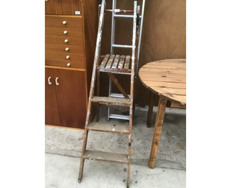 A VINTAGE WOODEN FOLDING STEP LADDER AND A TWELVE RUNG TWO SECTION EXTENDING LADDER 