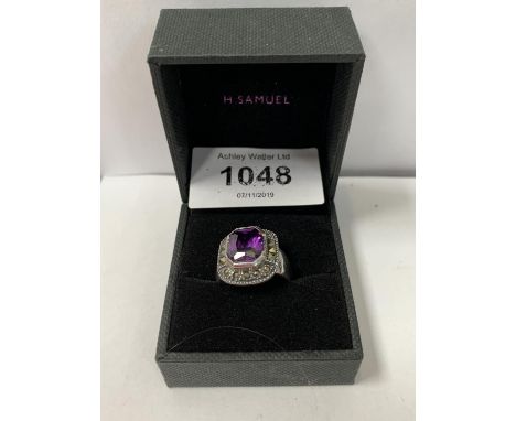 A BOXED RING WITH PURPLE STONE DESIGN 