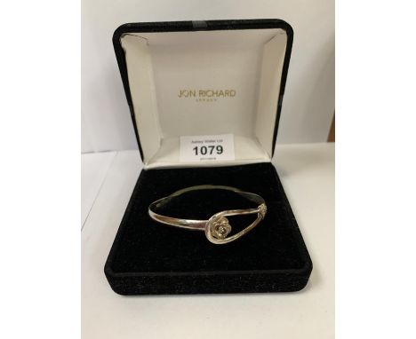 A SILVER BANGLE WITH FLOWER DESIGN 