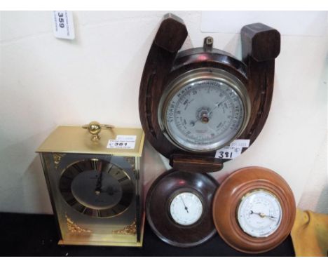 A carriage styled mantel clock by Junghans together with an oak cased barometer by A.C. Lowe & Co of Liverpool in the form of