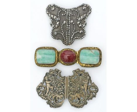 Drei Gürtelschließen. a) Silber, geprüft. Im Barockstil floral mit zwei Putten im Relief gearbeitet. D. 6x 9,5 cm; b) So gena