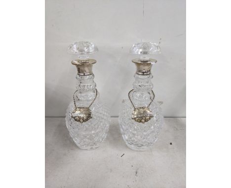 A pair of crystal cut decanters having silver rims, along with two silver decanter labels Location: 
