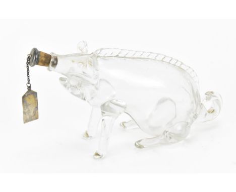 An Edwardian hand blown clear glass novelty decanter, modelled as a seated pig, with silver whisky label cork end fitted to t