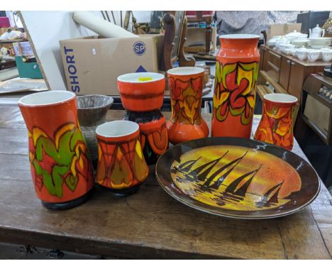 A collection of Poole pottery vases decorated in orange, yellow and red abstract patterns and another in a mottle grey and a 