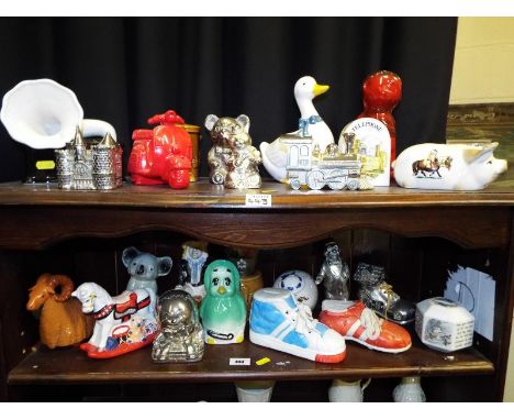 Two shelves containing a large quantity of ceramic and plated novelty money banks (qty)