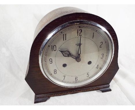 An oak cased mantel clock Arabic numerals on a silver dial