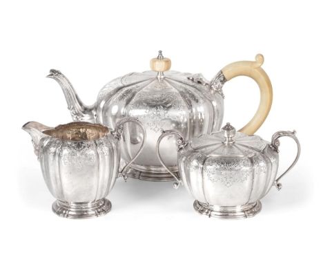 A Silver Three Piece Tea Service, Garrard &amp; Co, Birmingham 1967, fluted circular form, with an engraved foliate shell bor