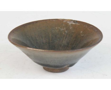 A Chinese Jin Dynasty (1115-1234) stoneware footed tea bowl, of conical form, with 'hare's fur' glaze in tones of brown, part