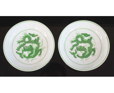A pair of Chinese porcelain famille vert circular footed dishes, each of shallow form, incise decorated with interior and ext