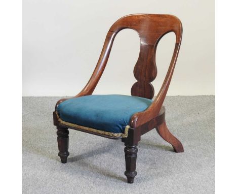 A late Regency carved rosewood nursing chair, with a blue padded seat