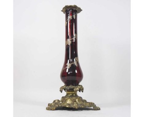 An ornate 19th century ruby glass lamp base, with vine decoration, on a scrolled brass base, 41cm high