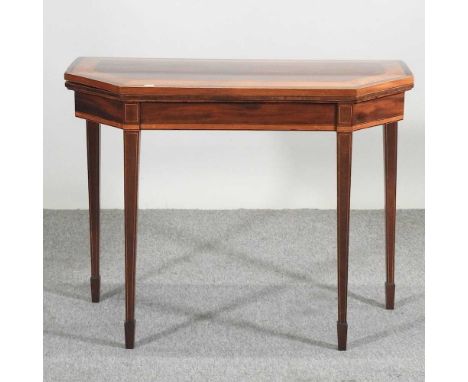 A George III mahogany and satinwood crossbanded card table, of canted rectangular shape, with a fold over top, on square tape