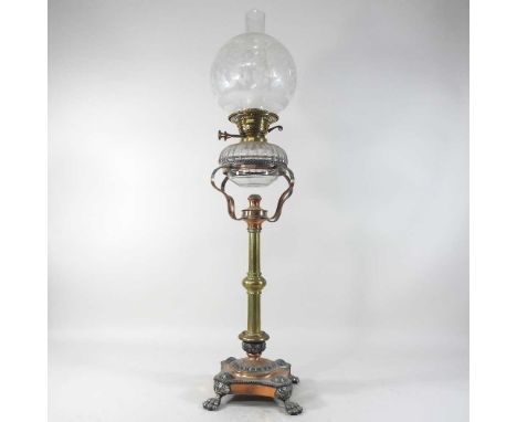 An unusual 19th century brass, copper and plated oil lamp, with a cut glass reservoir, on paw feet, with an etched glass shad