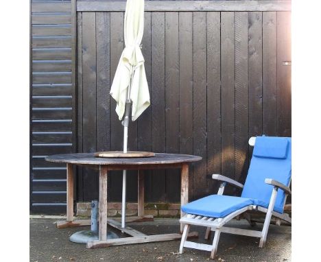 A teak folding steamer chair, with a loose cushion, together with a teak garden table, 150cm diameter and parasol, with base 