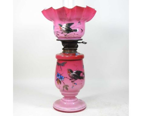 An 19th century French pink opaline glass oil lamp, painted with flowers, having a matching frilled shade, 55cm high overallC