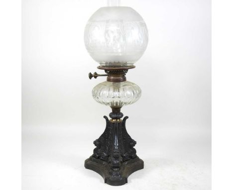 A Victorian cast iron oil lamp, with griffin supports, a cut glass reservoir, registered design diamond to base, having an et