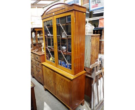 An antique mahogany bookcase,&nbsp;having arched cornice above pair of astragal glazed doors, and pair of panelled doors, on 