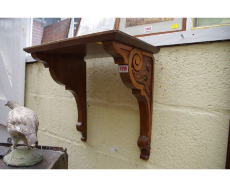 A Victorian walnut carved clock bracket, 43cm wide. 