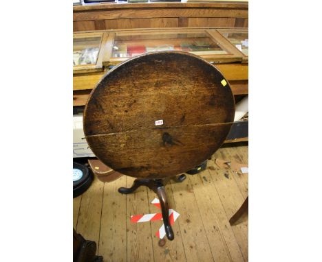 An antique oak circular tilt top tripod table, 65cm diameter. 