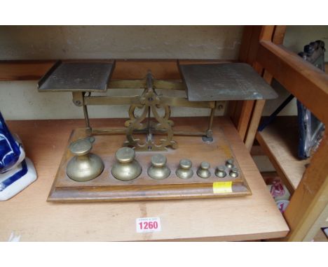 A set of STS brass postage scales,&nbsp;with weights, on rectangular wooden base, 28cm wide. 