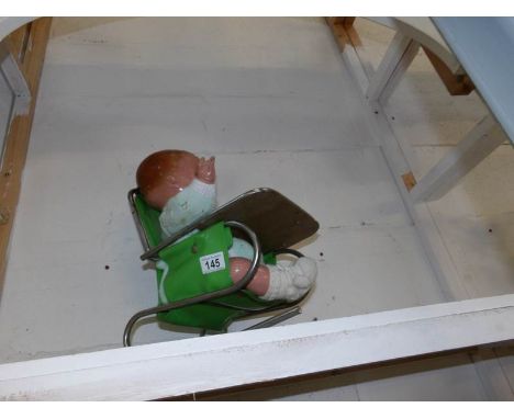 A vintage baby doll in chair