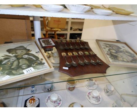 A pair of framed and glazed Hummel prints, 12 Hummel spoons including first edition and a Hummel clock