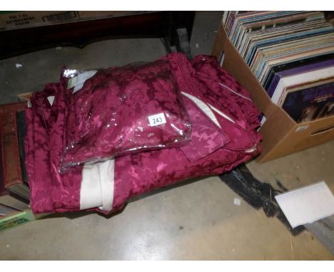 A quantity of dark red brocade curtains with tie backs