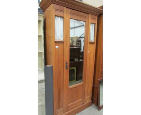 A satin walnut wardrobe with mirror door and glazed panels