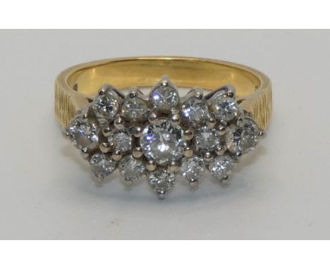 An 18ct gold and diamond cluster ring, panel set with brilliant cut stones, total weight approximately 1.3 cts, size O. 