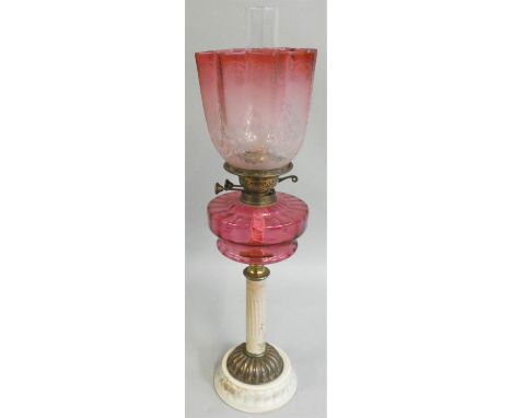 A late Victorian brass and glass oil lamp, with moulded ruby glass reservoir, acid etched ruby shade, ceramic and brass base 