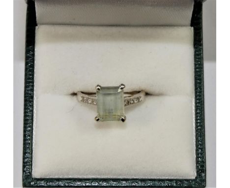 An 18ct white gold, aquamarine and diamond dress ring, claw set with and emerald cut stone, 10 x 7 mm, single cut diamond set