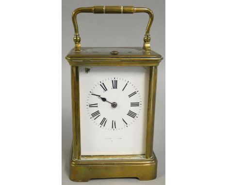 A French brass striking carriage clock, the white enamel dial with Roman numerals and retailer signed, the movement striking 