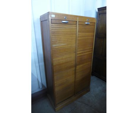 A mid 20th Century French light oak tambour front filing cabinet, 150cms h, 84cms w, 38cms d 