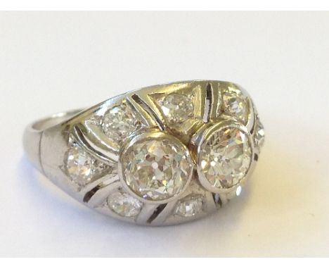 A platinum diamond set art deco style ring with two central diamonds (4.5mm diam) surrounded by eight smaller accent diamonds