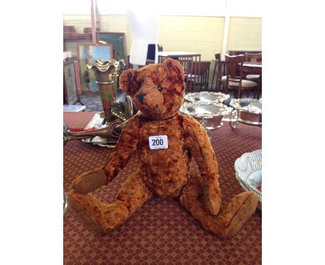 A jointed teddy bear in the style of Steiff.