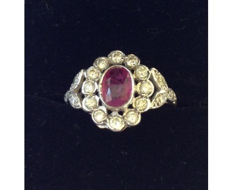 An 18 carat gold ruby and diamond set cluster ring.