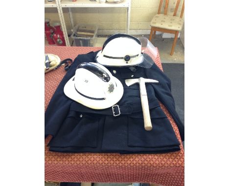A late 20th century Fireman's uniform together with two helmets and an Elwell Fireman's axe.