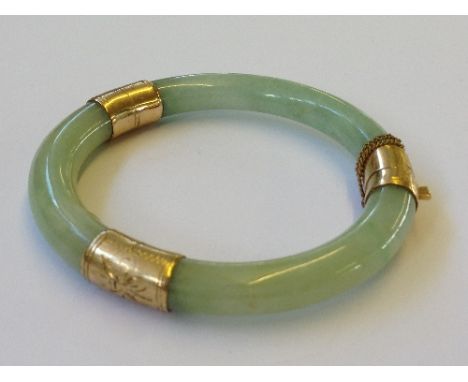 A 14 carat gold set jade bangle.