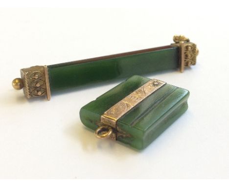 A jade and yellow metal bar brooch together with a similar gold mounted pendant.
