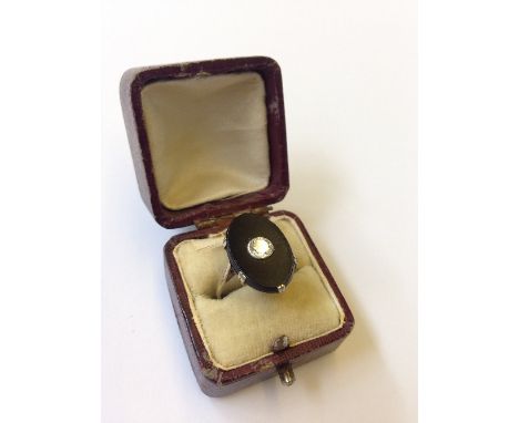 A white metal diamond and onyx set ladies' ring.
