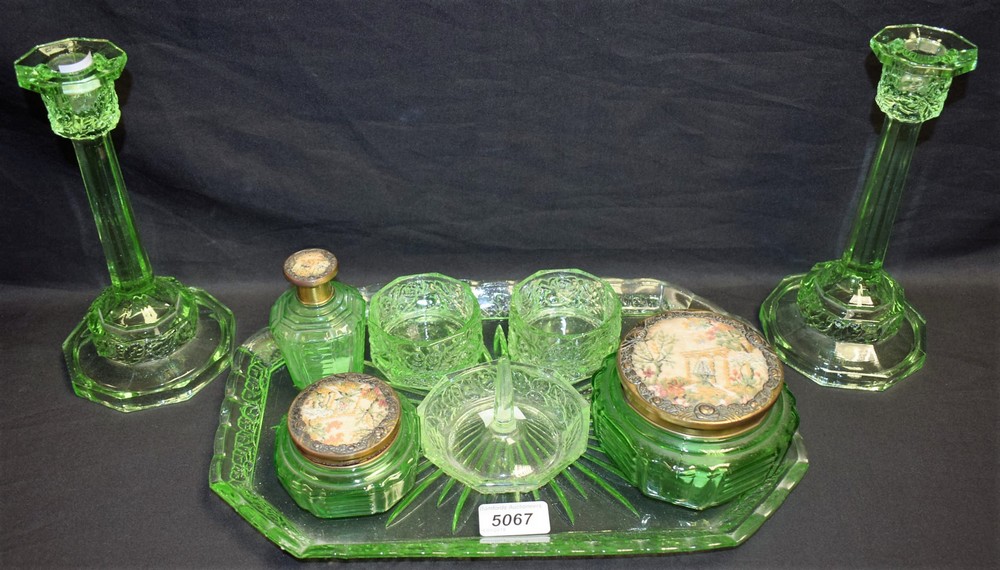 A 1930's pressed green glass dressing table set; three green glass jars