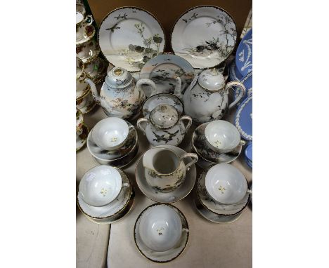 A Japanese eggshell part tea service with Mount Fuji scenes, comprising cups, saucers, cake and side plates and teapot ; anot