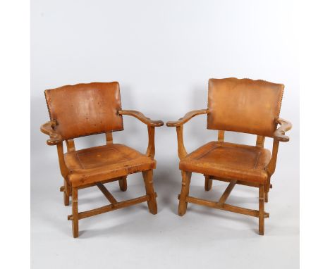 A pair of craftsman made Art and Craft oak armchairs, with leather upholstery, height 81cmMovement in arm joints on both chai