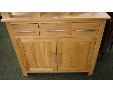 A modern, light solid oak sideboard of cupboards and drawers with brushed steel handles CONDITION REPORT; 110cm wide, 94cm ta