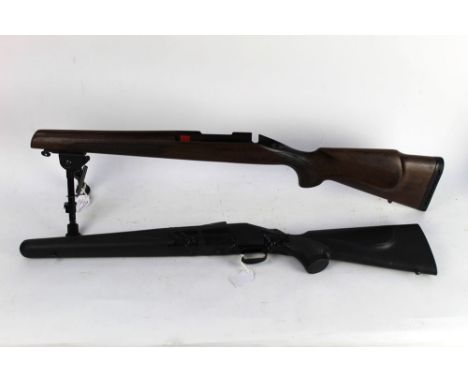 Two Remington 700 short action stocks, the first wooden and fitted with a bipod, the second synthetic and with magazine.