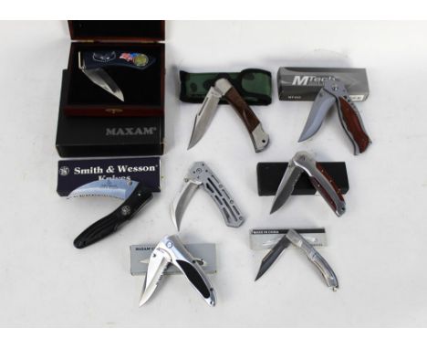 Eight folding pocket knives, to include Maxam, Smith & Wesson, MTech etc.   This bladed product is not for sale to people und