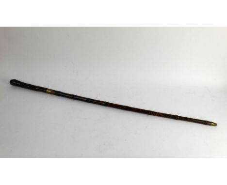 A bamboo sword stick, early 20th century, with brass collar opening to a diamond shaped blade.  Blade length 10 3/4", overall