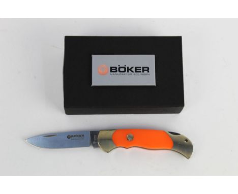A Boker Scout folding knife, with 3 1/2" blade with orange scale handles.  Overall length 21.5 cm with original box.  This bl