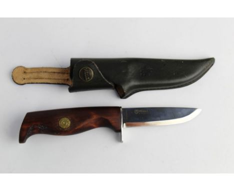 A Helle of Norway fixed blade hunting knife, with 3 1/2" blade, the wooden handle with inset 308 rifle cartridge and with lea