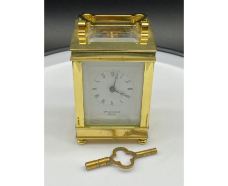 A Vintage Taylor &amp; Bligh England brass carriage clock, designed with bevel glass panels and comes with a key. [Over Wound